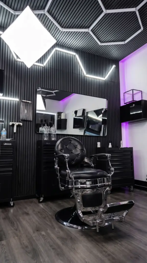 Alex's chrome-and-black barber chair under the hexagon lights